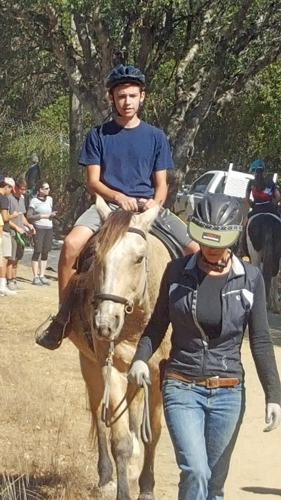 Tails and Tires - a young man is on a horse, being led by a helper.